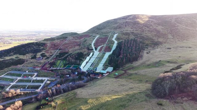 Cinematic drone orbit of Hillend Midlothian Snowsports Centre: Aerial view of artificial dry ski slopes and ski lifts near Edinburgh, Scotland