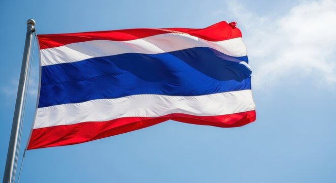 Thailands National Flag Waving Proudly Against a Clear Blue Sky.