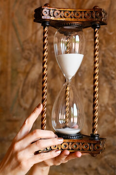 Hourglass held in hand symbolizing time passing and urgency