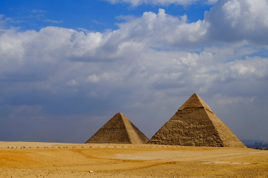 Cairo, Egypt. Dramatic skies at the Giza plateau with the pyramids in the background. 