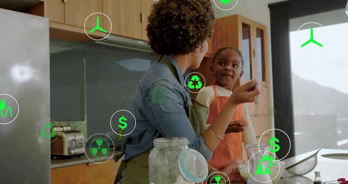 Mom guiding daughter reaching for jar, cracking egg at counter green eco icons teaching eco habits
