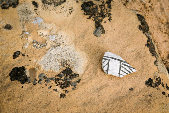 Coyote Canyon, New Mexico. Navajo Nation. Ancient pottery shard in desert sand archaeological detail