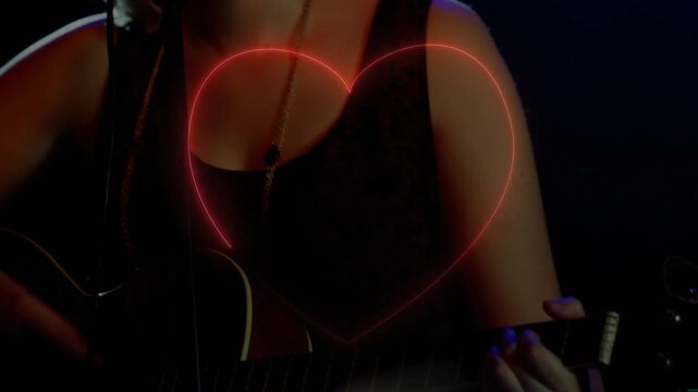 Female singer strumming guitar and singing in music set, camera revealing neon heart pulsing over