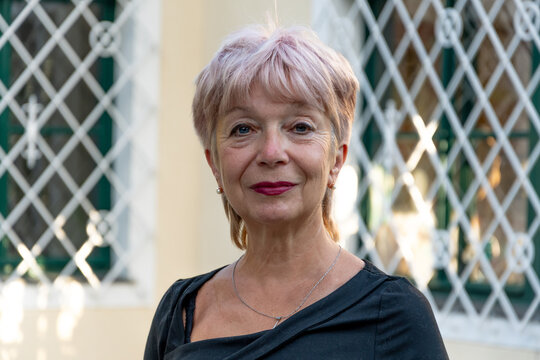 Portrait of 65 year old senior woman near architecture
