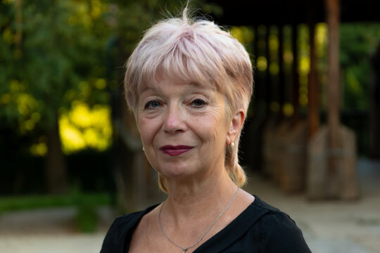 Portrait of 65-70 year old senior woman outdoors in park