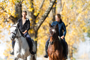 Obraz premium Image of two girls ride horses in the park