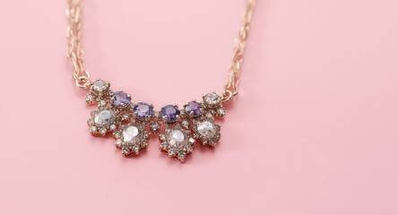 Obraz premium Close up of handmade gemstone necklace on pink surface featuring copy space