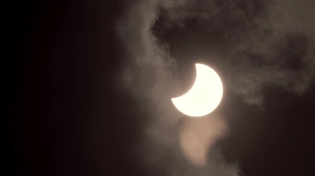 Dramatic Partial Solar Eclipse with Sun Breaking Through Dark Clouds