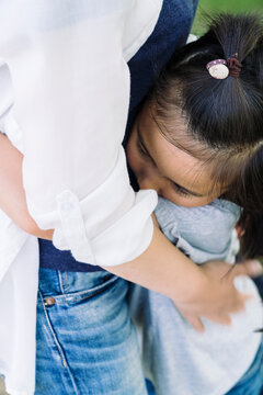 A child hugs a person tightly, finding comfort and security in their embrace. The scene captures a moment of deep connection and love between two individuals.