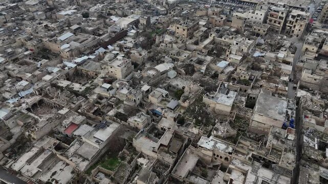 High-angle aerial drone shot over the devastated Old City of Aleppo, Syria, showing extensive ruins and rubble from the conflict