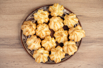 Freshly baked golden profiteroles on a decorative plate