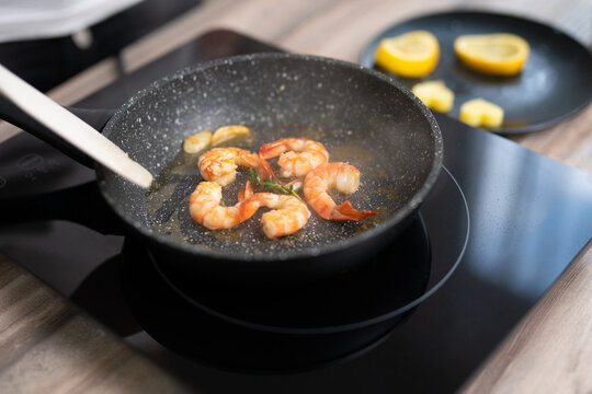 Sizzling shrimp with garlic and fresh herbs in a frying pan