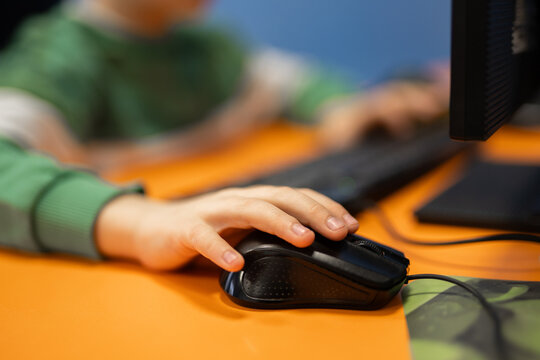 Young boy using a computer mouse in a digital classroom