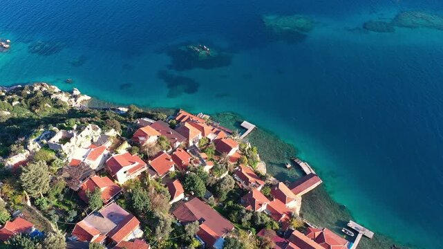 Aerial view of Kekova sunken city, showcasing ancient ruins amid the turquoise waters and rugged natural coastline of southern Turkey's Mediterranean region.