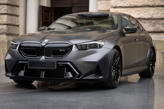 LVIV, UKRAINE - SEPTEMBER 28, 2024: Three-quarter front view of a modern matte grey BMW M5 G90 luxury sports sedan parked outdoors
