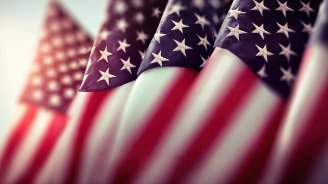 Row of American flags waving gently in the breeze with soft sunlight creating a patriotic atmosphere