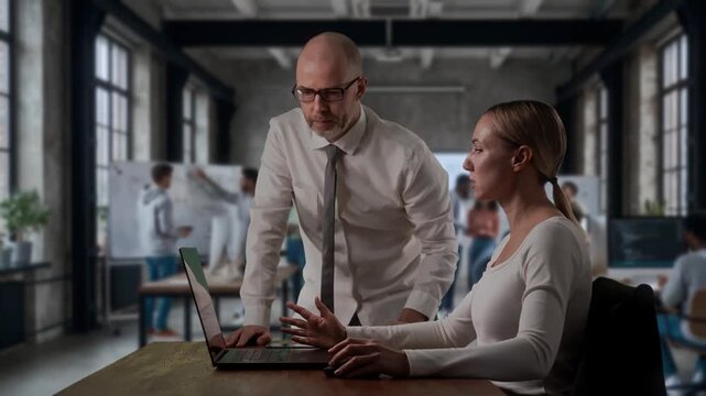Manager Instructs Female Trainee On Technical Tasks During Team Activity In Studio Environment