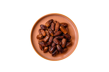 Fototapeta premium Dried dates on a ceramic plate for Ramadan or Iftar. Dates fruit as a background