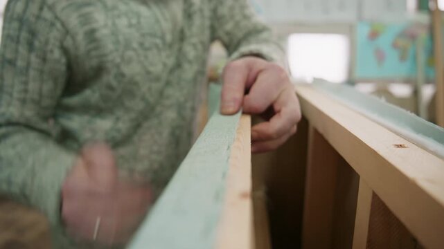 Upholsterer using a staple gun on wooden furniture frame