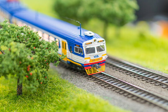 Vibrant toy train set against a green landscape backdrop, with a blue and yellow locomotive on moving tracks - Kyiv, Ukraine - June 7, 2025