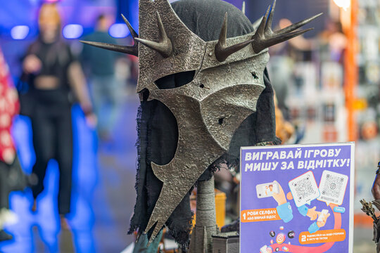 Person in Sauron mask Lord of the Rings, donning dragon-headed costume Metal helmet with spikes, red capecloak contrasting with monochrome attire Indoor setting - Kyiv, Ukraine - June 7, 2025