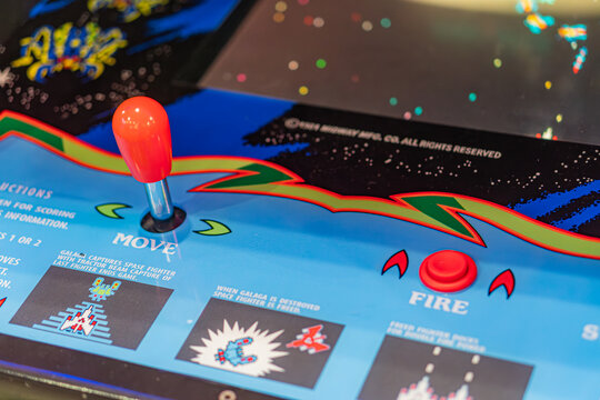 Vibrant arcade game cabinet with orange button, blue-red joystick, and additional red buttons Retro arcade aesthetic, hinting at interactive gaming and Galaga theme - Kyiv, Ukraine - June 7, 2025