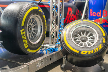 Fototapeta premium Two Formula 1 tires on stands, left tire facing forward with visible tread pattern and Pirelli logo, right tire showing inner side and rim spokes Tires from an angl - Kyiv, Ukraine - June 7, 2025