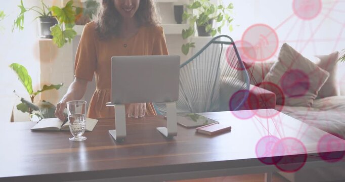 Animation of network of connections with media icons over caucasian woman using tablet