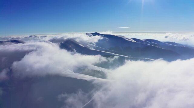 An extraordinary mountain valley covered with fluffy clouds at winter sunset