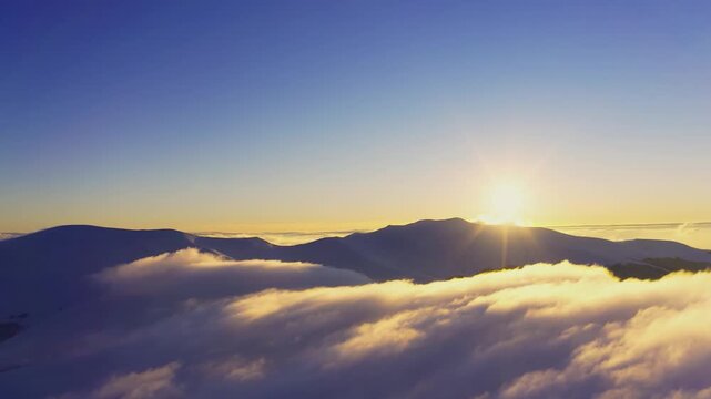 Wonderful view of extraordinary cloudy valley and bright orange sunset