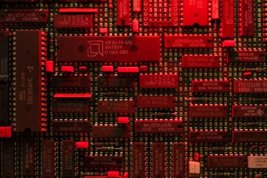 Vintage computer motherboard with AMD and NEC microchips in red light