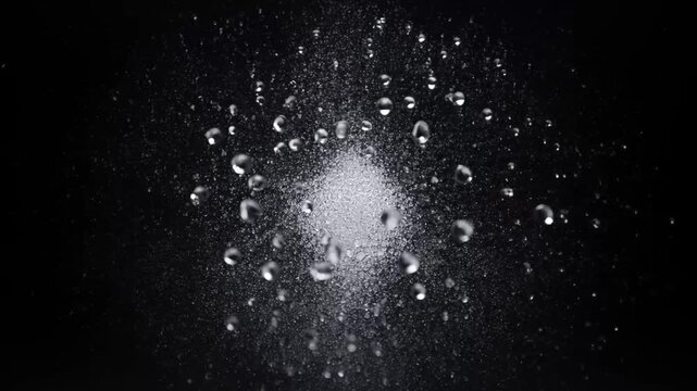 Water droplet splash spray bubble on black background abstract macro motion with floating bubble glow and white powder explosion dust burst splash dark dust cloud particle explosion energy