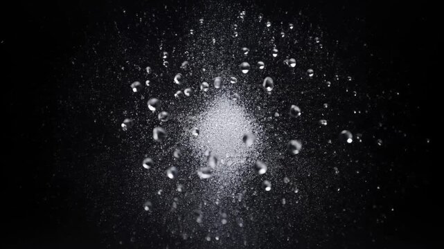 Ephemeral Burst of Droplets: A captivating display of tiny droplets, frozen in motion against a stark dark canvas, evoking a sense of raw energy and fleeting beauty.