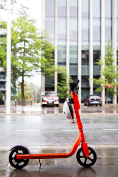 white helmet hanging on an orange electric scooter in Canberra the capital city of Australia