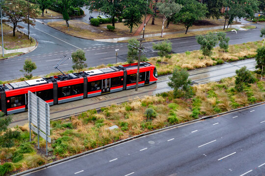 light rail track in Canberra with a red train from above