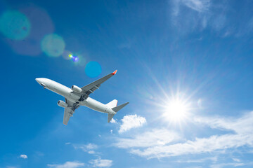 Obraz premium commercial airplane flies through white clouds in the blue sky during a high-altitude aviation flight for travel and transportation