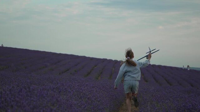 Child, airplane, lavender field, young girl playing, running with toy plane, dreaming of flying.