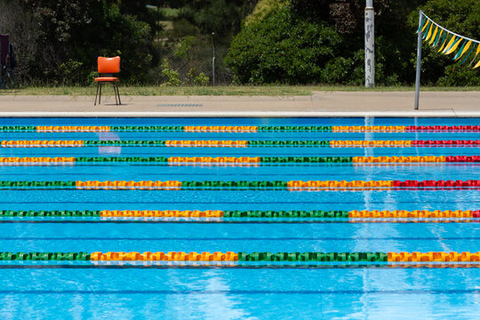 Colourful lane ropes set up in a public swimming pool and chair waiting for a swim competition