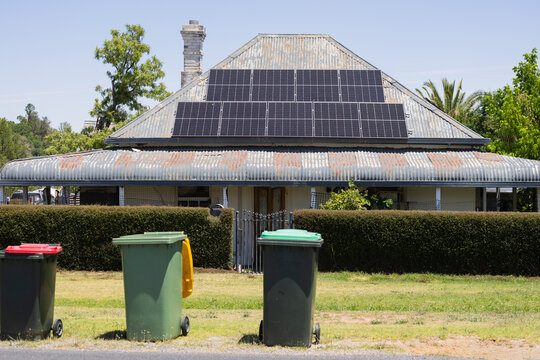 Solar panels on the roof of an older Australian house with bull nose verandah