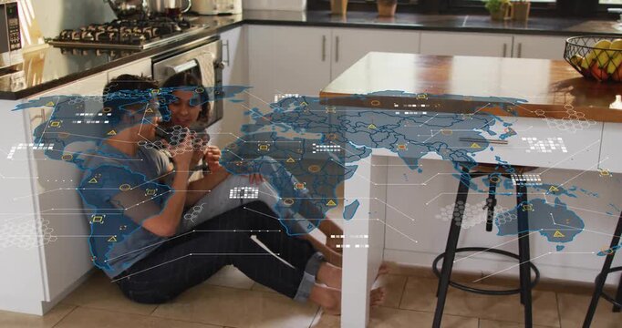 Couple holding coffee mugs on kitchen floor as world map overlay expanding glowing tech nodes