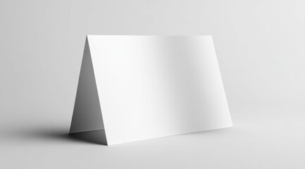 Blank white folded card standing on a clean, light gray surface with soft shadows
