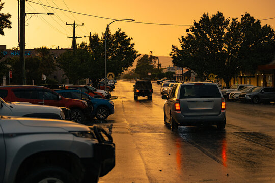 Heavy rain in busy country town at sunset
