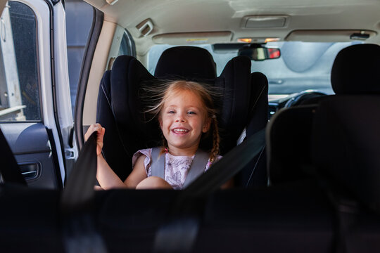 Happy kid seated in car buckled into extended rear facing ERF seat