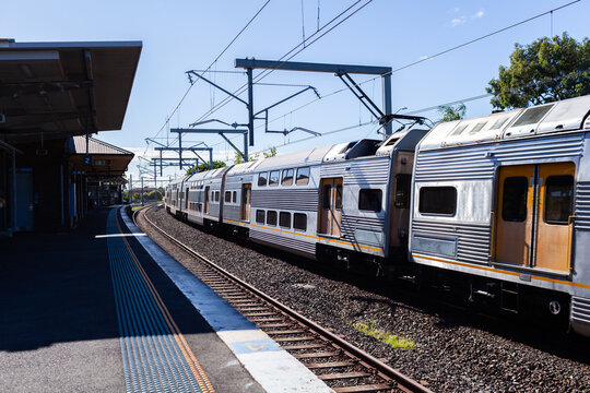Passenger train passing platform of Narwee station in Sydney suburb