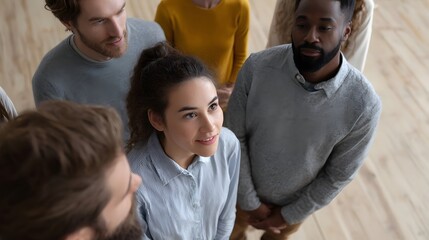 Fototapeta premium A diverse group of people looking upwards in attentive discussion in a modern indoor setting