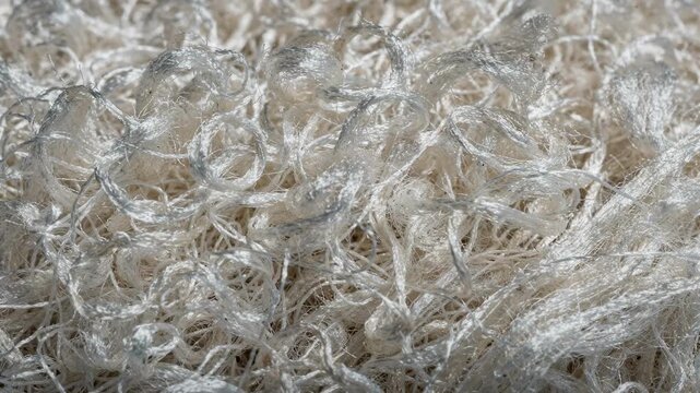 Closeup medium view of bulked polypropylene filaments with a textured voluminous appearance ideal for plush cushioned carpet backing enhancing comfort and resilience.