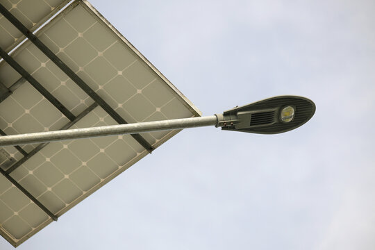 Solar powered street light against cloudy sky