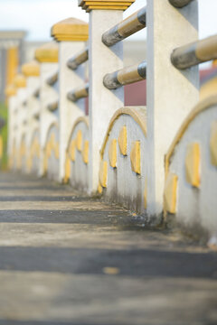 Weathered concrete railing with yellow and black railings