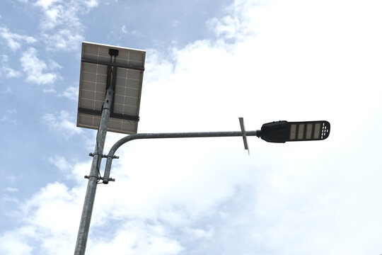 Solar powered street light against cloudy sky