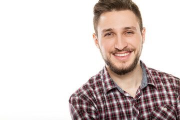 Fototapeta premium Close up portrait of handsome smiling young man with beard wearing plaid shirt looking at camera isolated on white background
